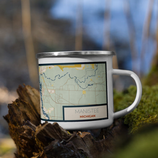 Right View Custom Manistee Michigan Map Enamel Mug in Woodblock on Grass With Trees in Background