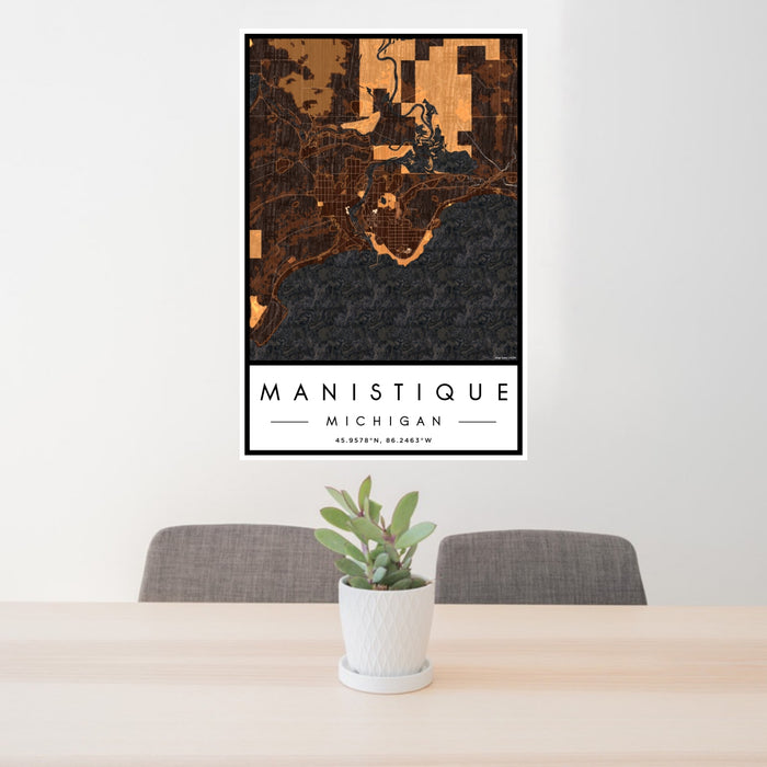 24x36 Manistique Michigan Map Print Portrait Orientation in Ember Style Behind 2 Chairs Table and Potted Plant