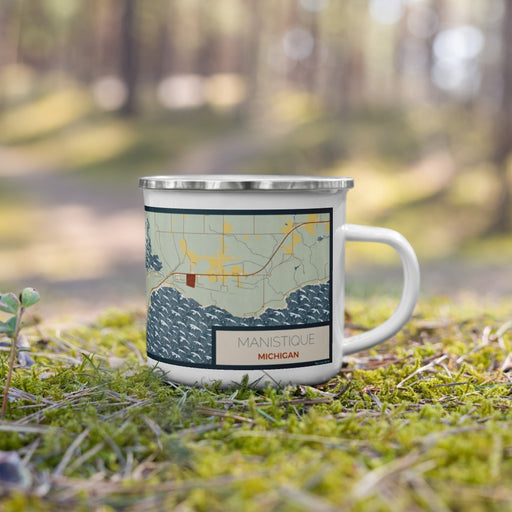 Right View Custom Manistique Michigan Map Enamel Mug in Woodblock on Grass With Trees in Background