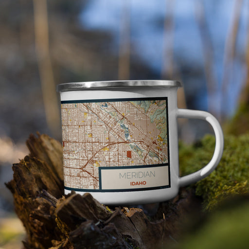 Right View Custom Meridian Idaho Map Enamel Mug in Woodblock on Grass With Trees in Background