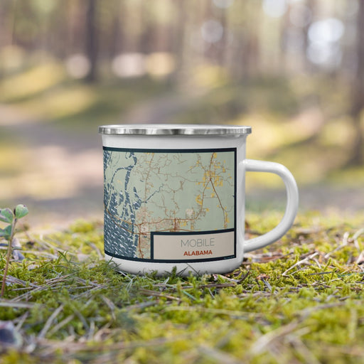 Right View Custom Mobile Alabama Map Enamel Mug in Woodblock on Grass With Trees in Background