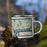 Right View Custom Mooselookmeguntic Maine Map Enamel Mug in Woodblock on Grass With Trees in Background