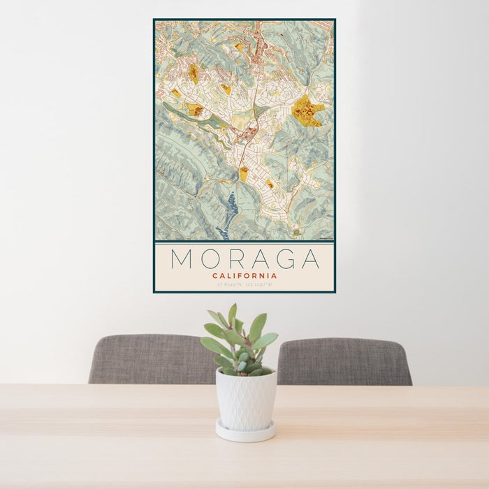 24x36 Moraga California Map Print Portrait Orientation in Woodblock Style Behind 2 Chairs Table and Potted Plant