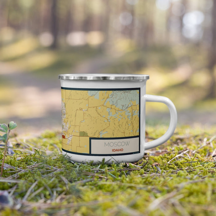 Right View Custom Moscow Idaho Map Enamel Mug in Woodblock on Grass With Trees in Background