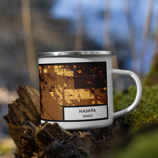 Right View Custom Nampa Idaho Map Enamel Mug in Ember on Grass With Trees in Background
