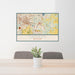24x36 Okemos Michigan Map Print Lanscape Orientation in Woodblock Style Behind 2 Chairs Table and Potted Plant
