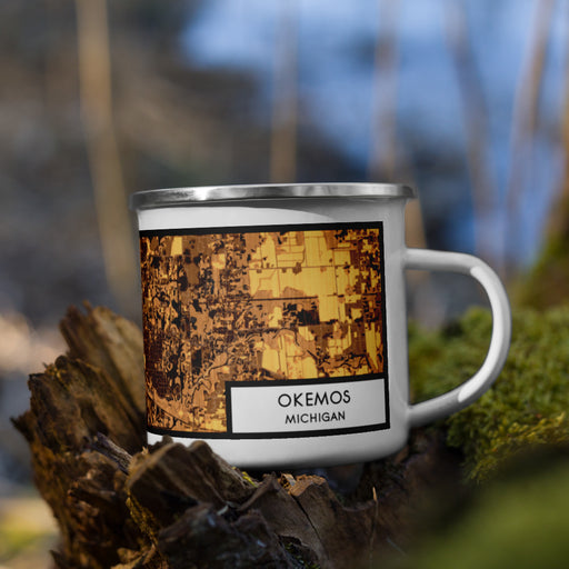 Right View Custom Okemos Michigan Map Enamel Mug in Ember on Grass With Trees in Background