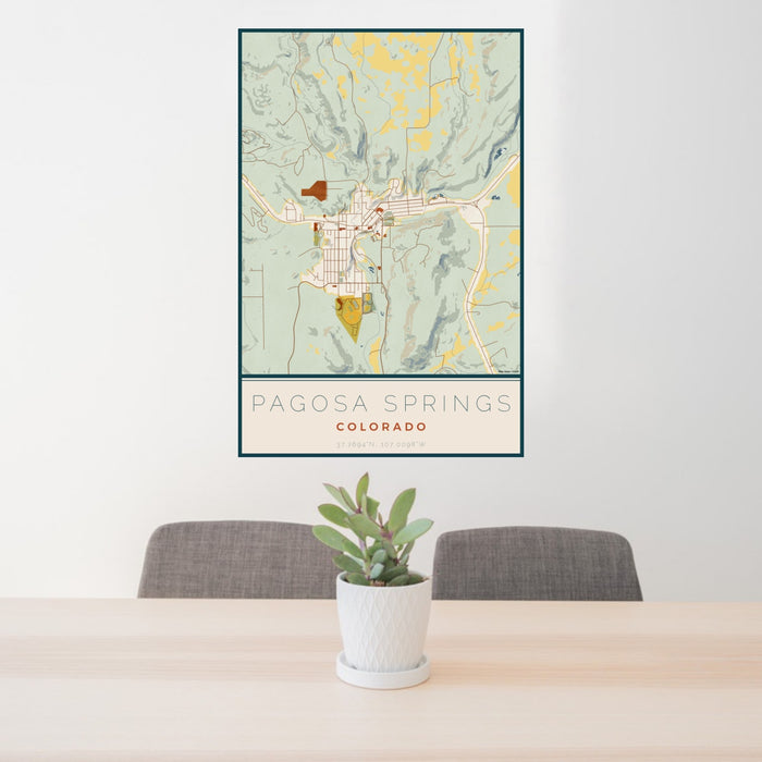 24x36 Pagosa Springs Colorado Map Print Portrait Orientation in Woodblock Style Behind 2 Chairs Table and Potted Plant