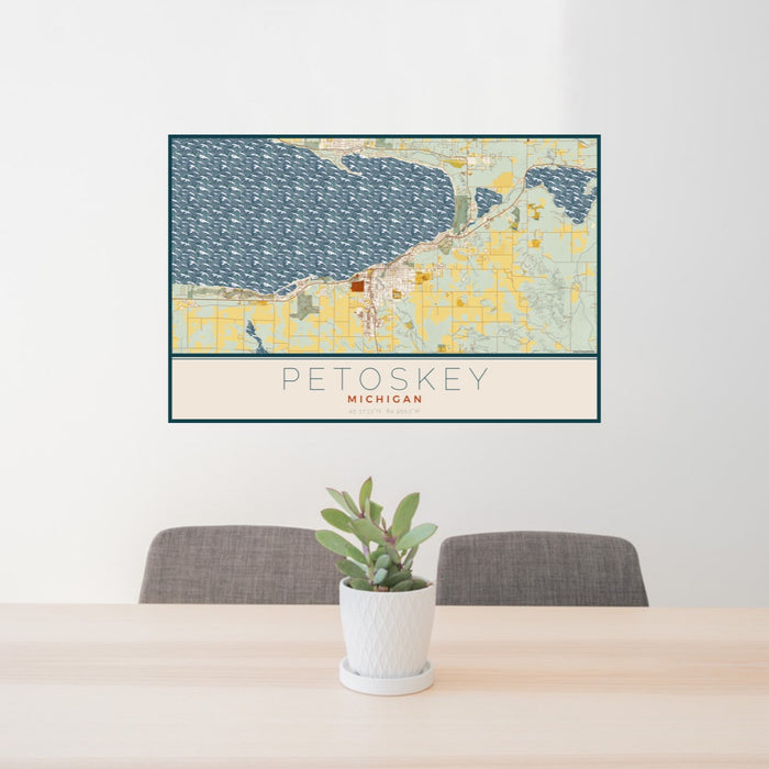 24x36 Petoskey Michigan Map Print Landscape Orientation in Woodblock Style Behind 2 Chairs Table and Potted Plant