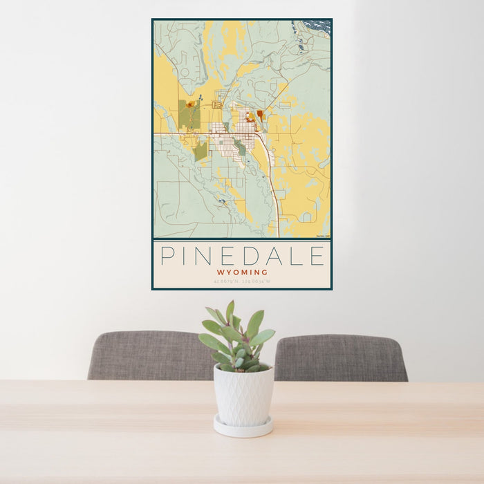 24x36 Pinedale Wyoming Map Print Portrait Orientation in Woodblock Style Behind 2 Chairs Table and Potted Plant