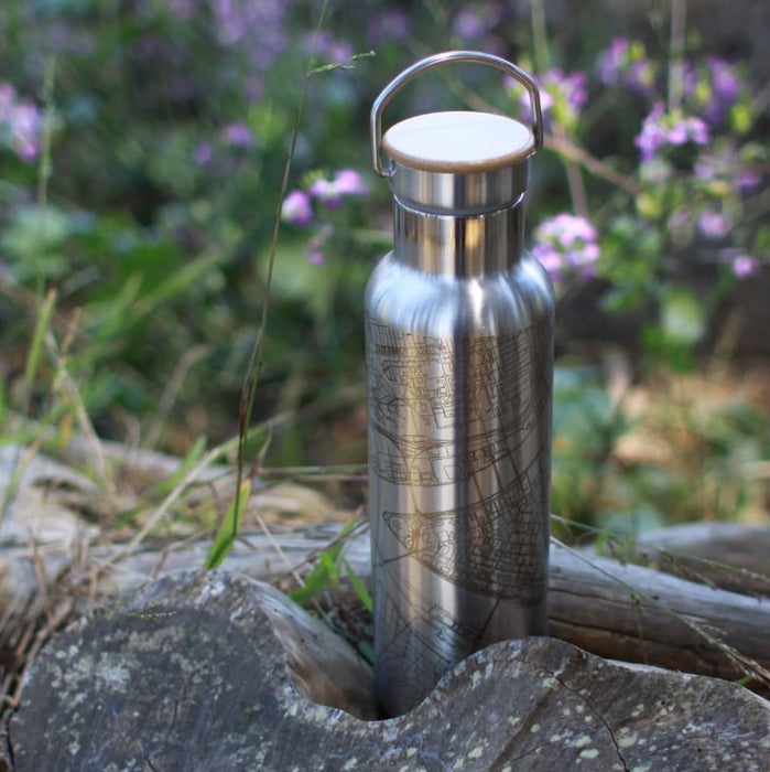20oz Stainless Steel Insulated Bottle with Bamboo Top with Custom Engraving of Map on Tree Stump Next to Flowers
