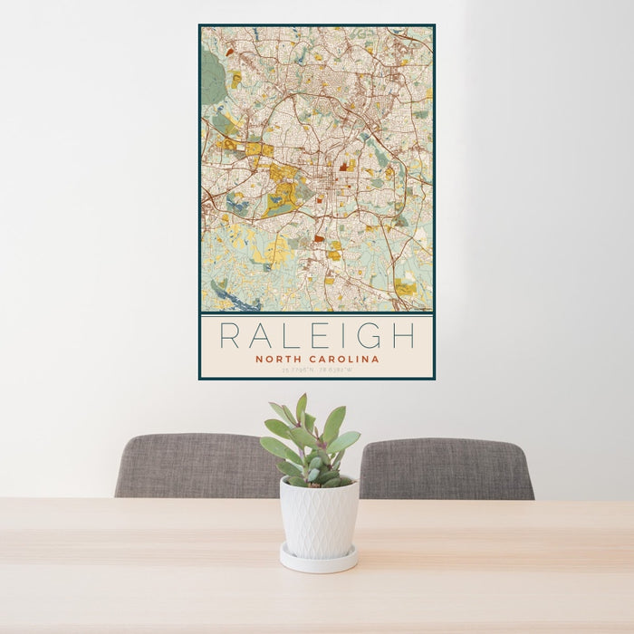 24x36 Raleigh North Carolina Map Print Portrait Orientation in Woodblock Style Behind 2 Chairs Table and Potted Plant