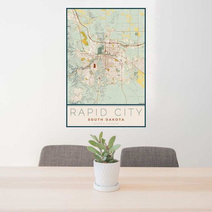 24x36 Rapid City South Dakota Map Print Portrait Orientation in Woodblock Style Behind 2 Chairs Table and Potted Plant