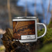 Right View Custom Rifle Colorado Map Enamel Mug in Ember on Grass With Trees in Background