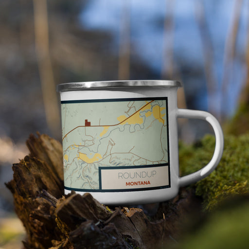 Right View Custom Roundup Montana Map Enamel Mug in Woodblock on Grass With Trees in Background