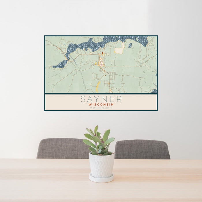 24x36 Sayner Wisconsin Map Print Lanscape Orientation in Woodblock Style Behind 2 Chairs Table and Potted Plant
