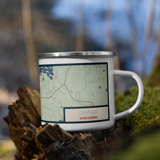 Right View Custom Sayner Wisconsin Map Enamel Mug in Woodblock on Grass With Trees in Background