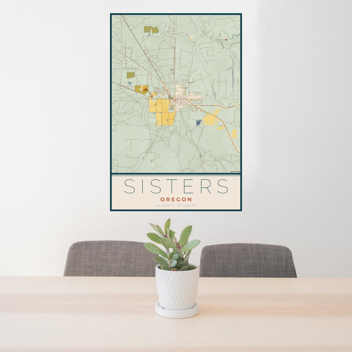 24x36 Sisters Oregon Map Print Portrait Orientation in Woodblock Style Behind 2 Chairs Table and Potted Plant
