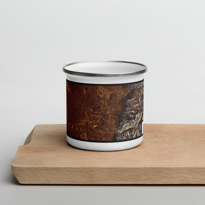 Front View Custom Taos New Mexico Map Enamel Mug in Ember on Cutting Board