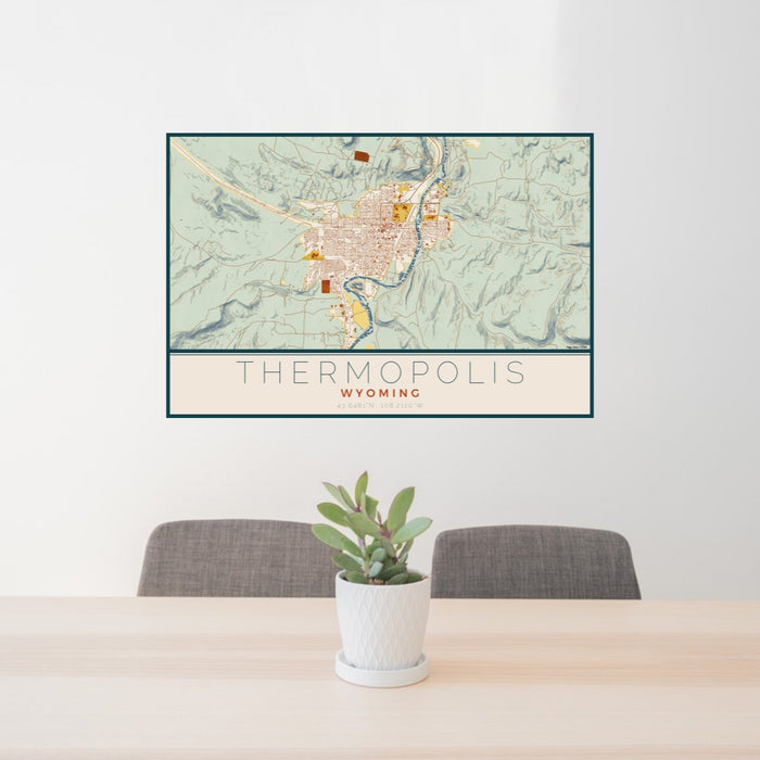 24x36 Thermopolis Wyoming Map Print Lanscape Orientation in Woodblock Style Behind 2 Chairs Table and Potted Plant