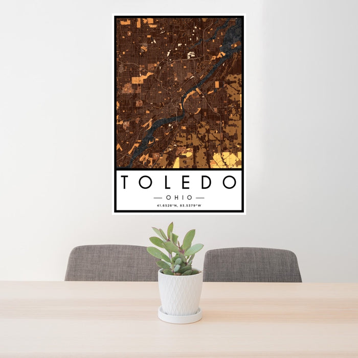 24x36 Toledo Ohio Map Print Portrait Orientation in Ember Style Behind 2 Chairs Table and Potted Plant