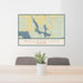 24x36 Walloon Lake Michigan Map Print Lanscape Orientation in Woodblock Style Behind 2 Chairs Table and Potted Plant