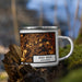 Right View Custom West Bend Wisconsin Map Enamel Mug in Ember on Grass With Trees in Background